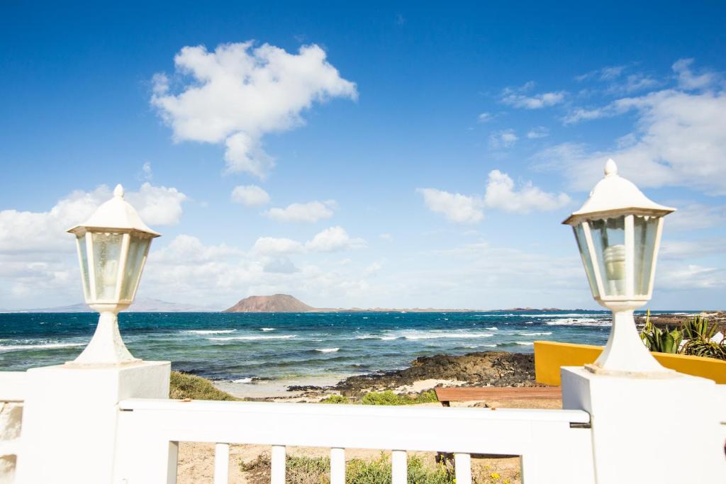 a white fence with a view of the ocean at Villa Los Remos in Corralejo