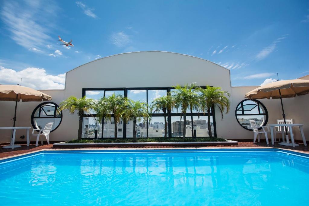 聖保羅的住宿－特蘇宮公寓酒店，一座棕榈树游泳池和一座建筑