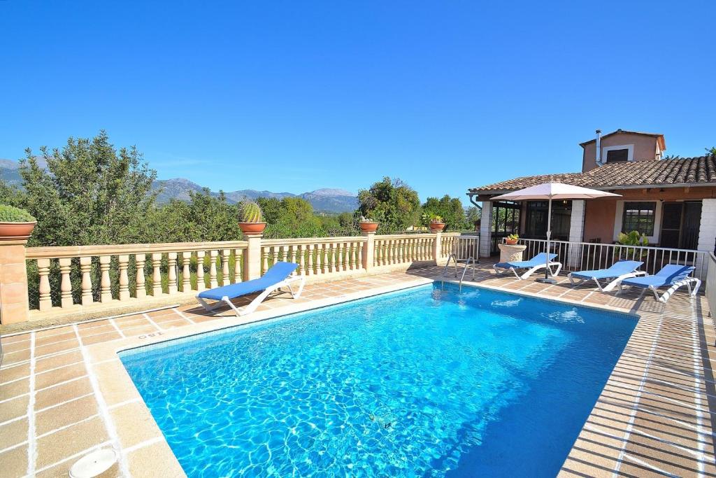 einen Pool mit zwei Stühlen und ein Haus in der Unterkunft Villa Tramuntana 171 by Mallorca Charme in Inca