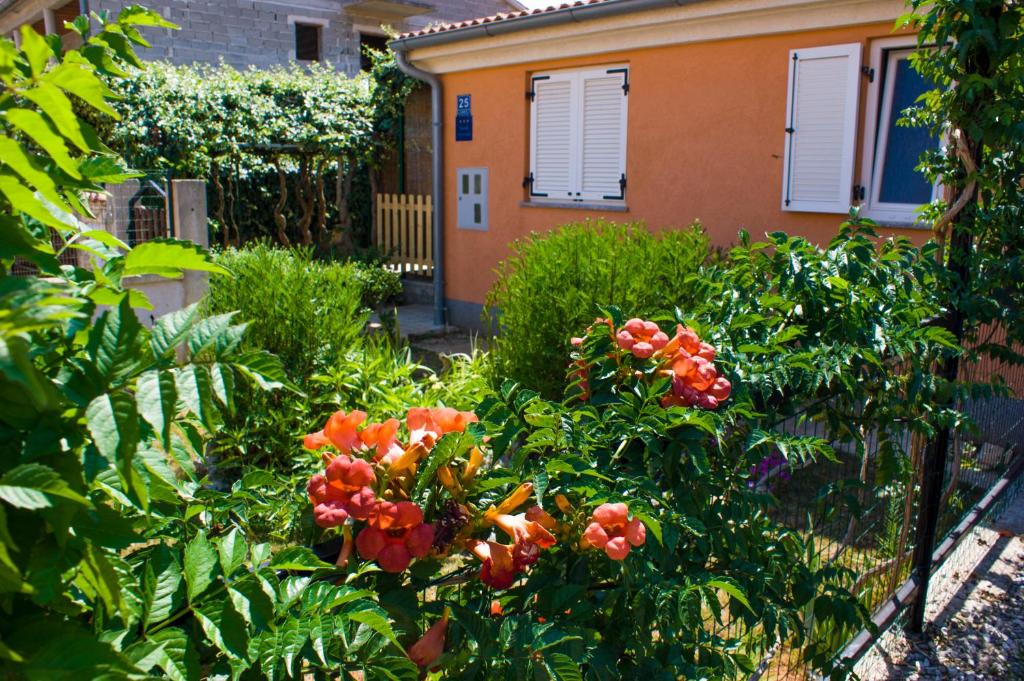 een tuin met bloemen voor een huis bij Apartmani Arijana Medulin in Medulin