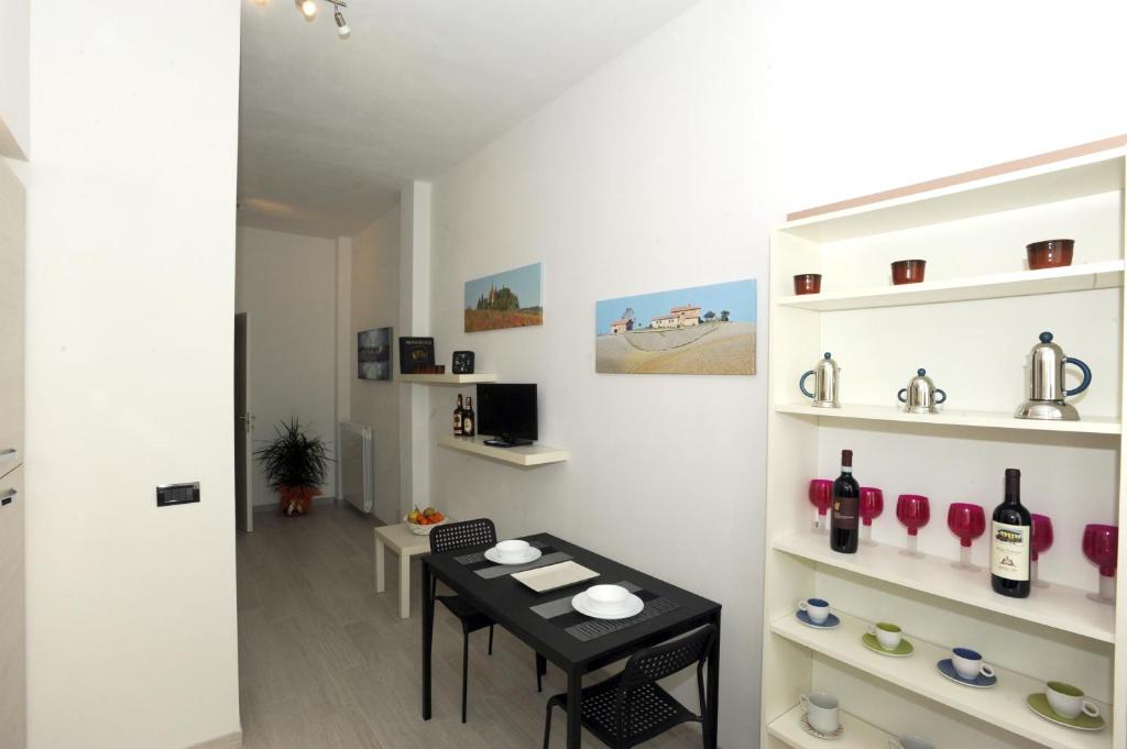 a room with a table and shelves with wine bottles at Le Gemme 1 in Empoli