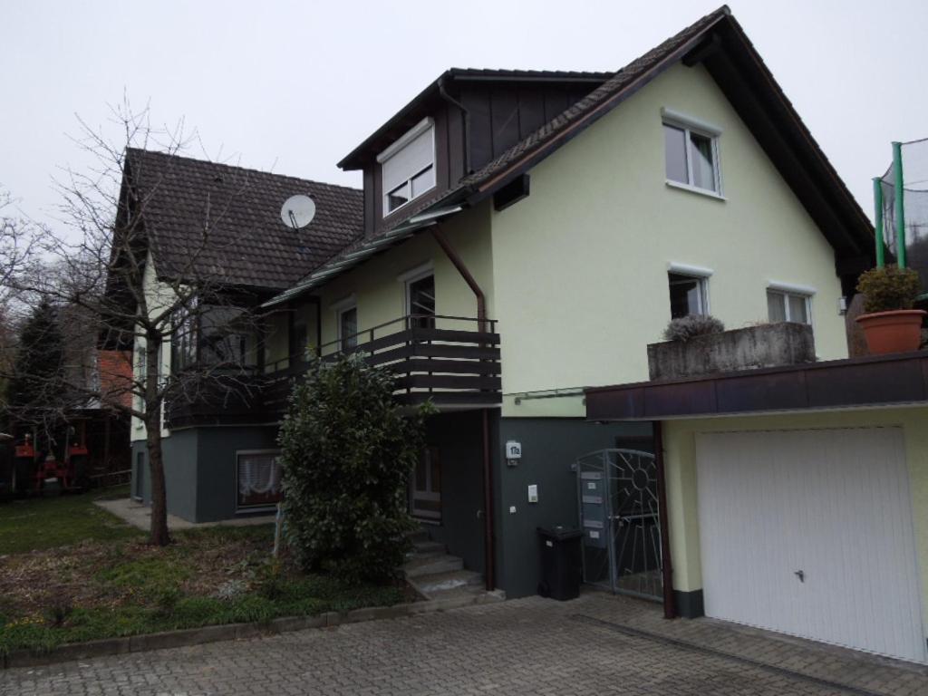 a white house with a black roof and a garage at Angelas Apartment in Grenzach-Wyhlen