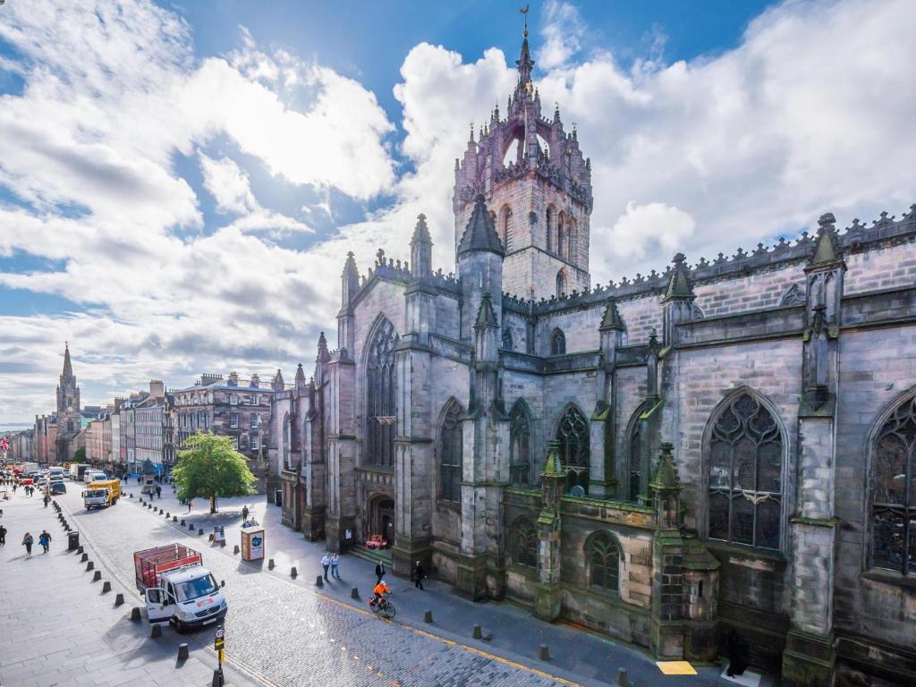 a large building with a tower on a city street at Festival Lets in Edinburgh