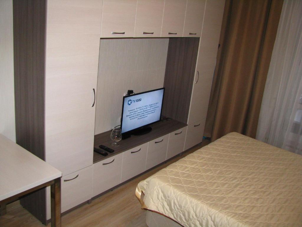 a bedroom with a bed and a tv in a cabinet at Студия у метро Московская in Saint Petersburg