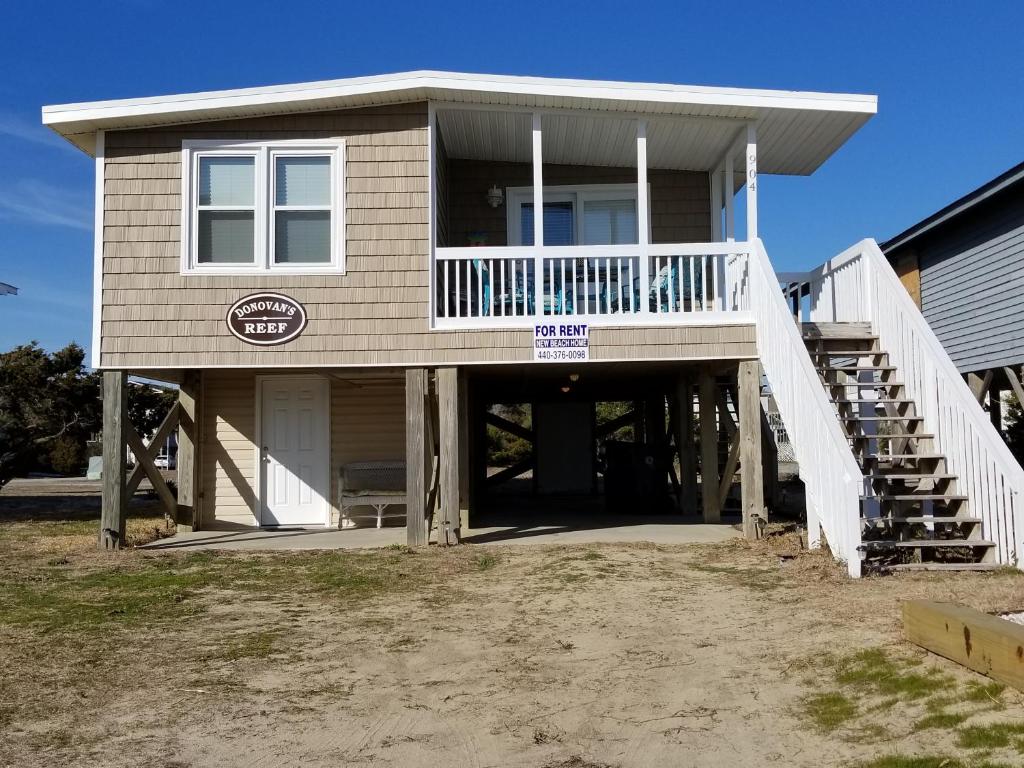 a large house with a porch and a balcony at donovan"s Reef in Oak Island