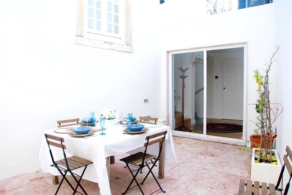 リスボンにあるBairro Alto apartment with a large patioの白いダイニングルーム(白いテーブルと椅子付)