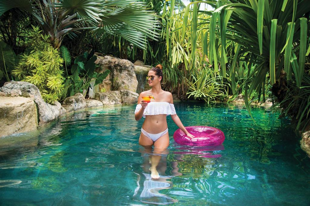 Eine Frau im Bikini in einem Pool mit Frisbee. in der Unterkunft Sweetfield Manor in Bridgetown