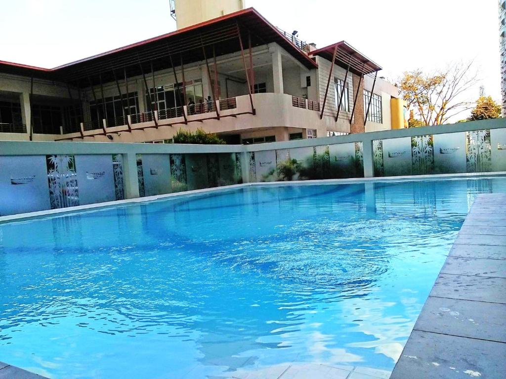 une grande piscine bleue en face d'un bâtiment dans l'établissement Saint Croix at Tagaytay Prime Residences, à Tagaytay