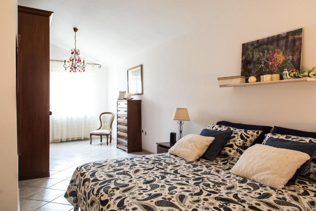 1 dormitorio con 1 cama y 1 silla en Casa Michela, en Vico del Gargano