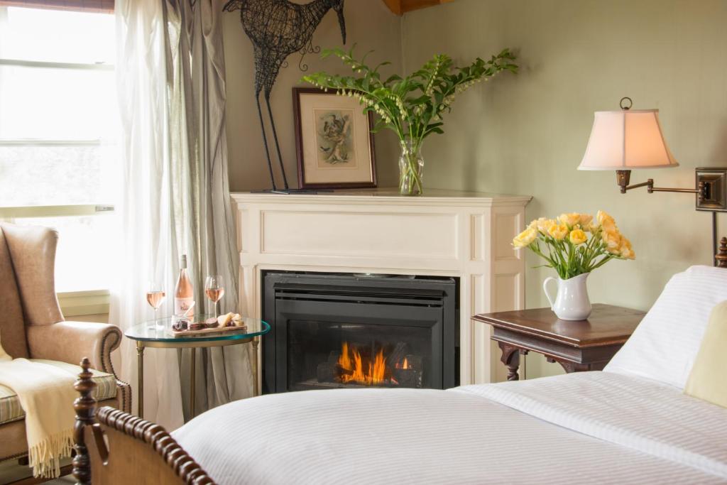 a living room with a fireplace and a bed at The Bradley Inn in New Harbor