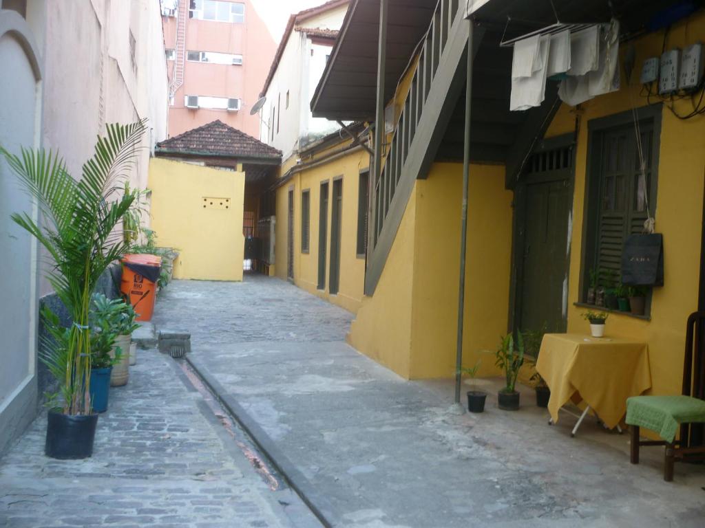 an empty alley with a table and yellow buildings at Cortiço da Lapa in Rio de Janeiro