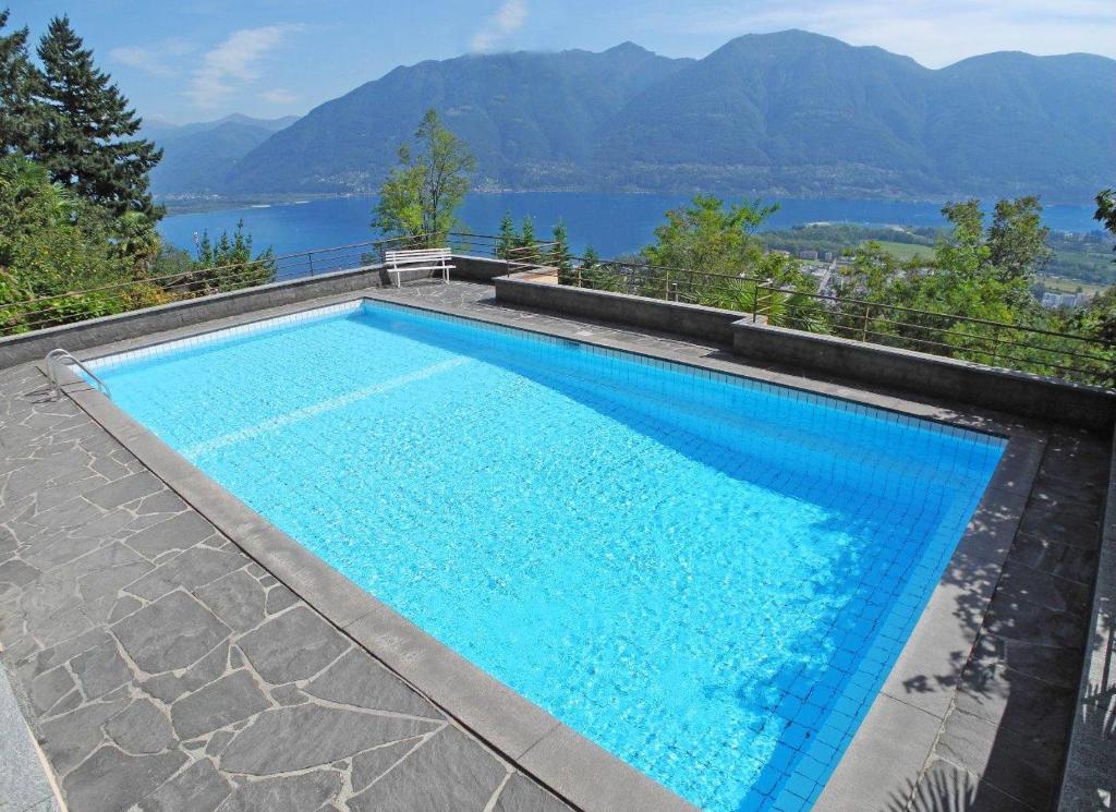 una piscina con vista sulle montagne di Villa Orselina App 7273 a Orselina