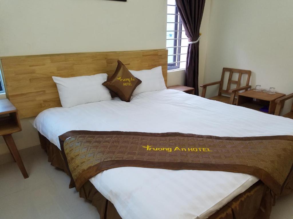 ein Hotelzimmer mit einem großen Bett und einem Schild mit einem Gehäuse in der Unterkunft Trường An Hostel in Việt Trì