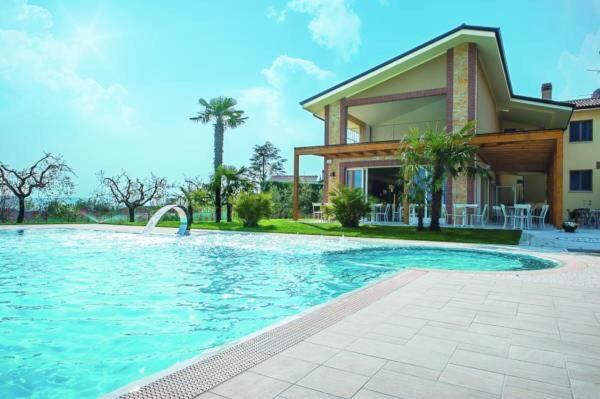 une grande piscine devant une maison dans l'établissement Locanda Corte Montioni, à Lazise