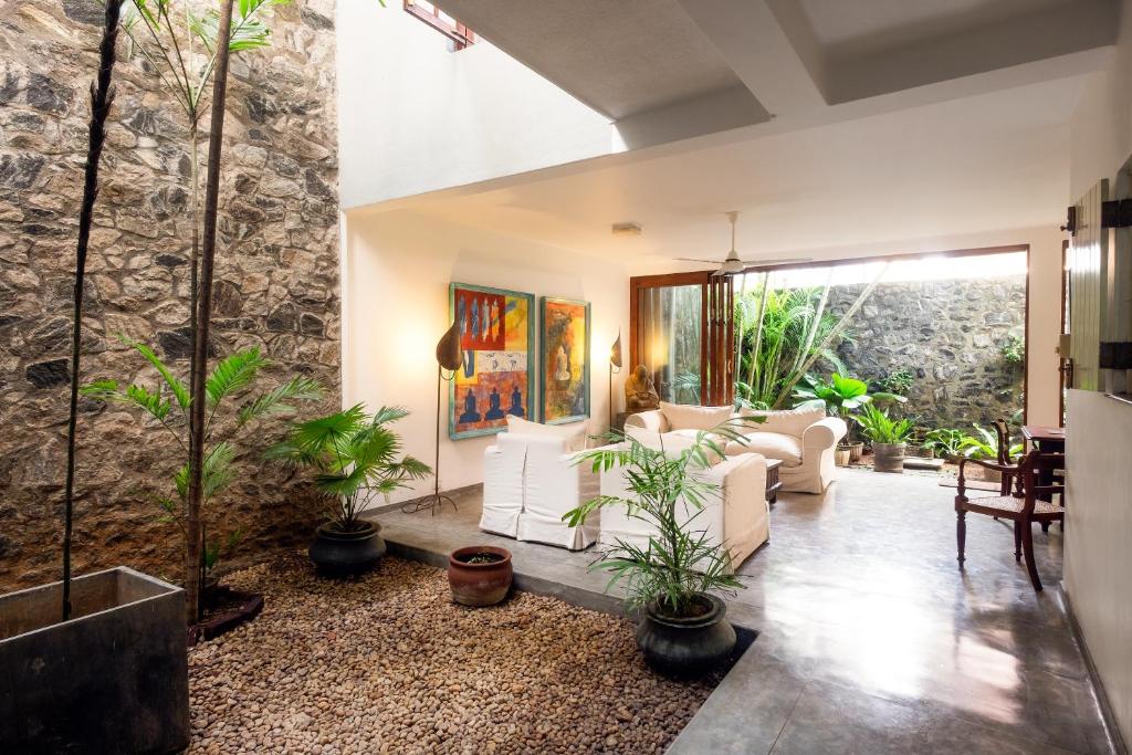 una sala de estar con plantas y una pared de piedra. en Mount Lodge Boutique Hotel en Mount Lavinia