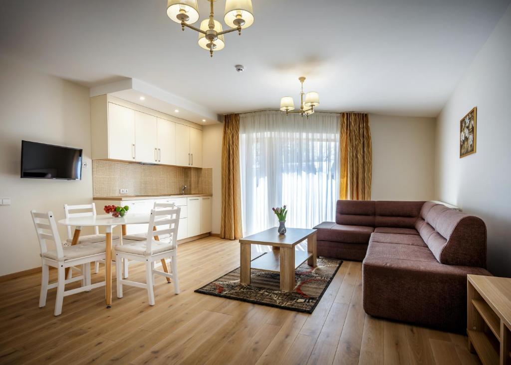 ein Wohnzimmer mit einem Sofa und einem Tisch in der Unterkunft Vila Elegancija in Palanga
