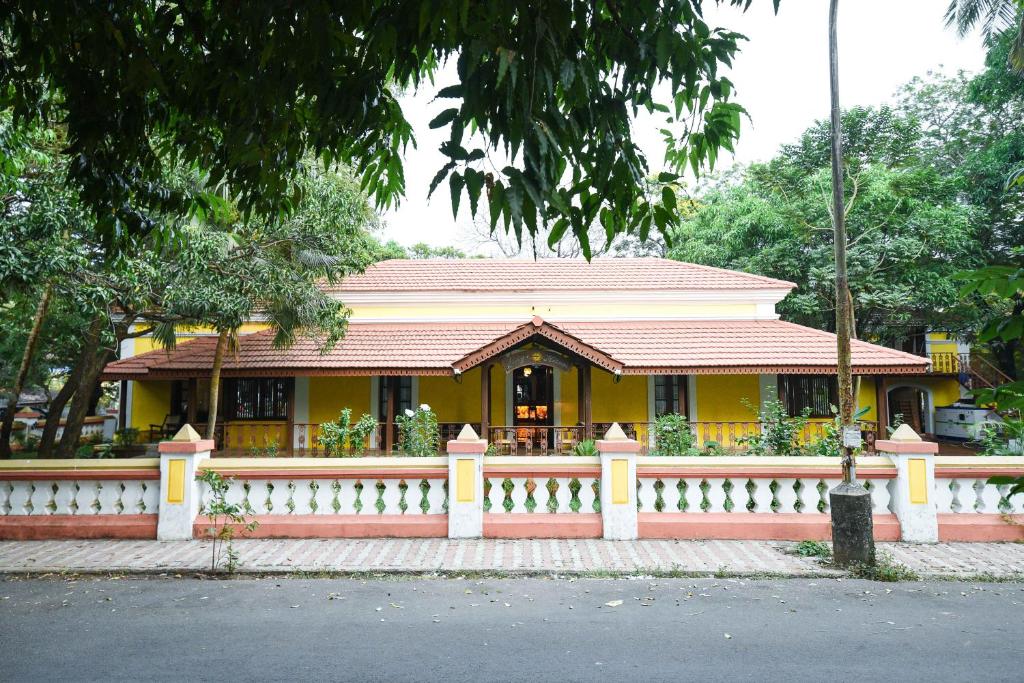 a yellow house with a fence in front of it at Surya Kiran Heritage Hotel in Panaji