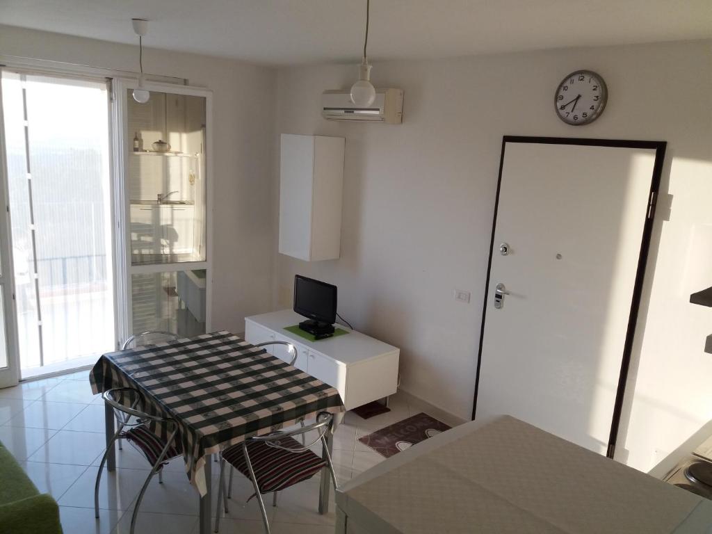 a living room with a table and a clock on the wall at Bicchi Belvedere Scarlino in Scarlino