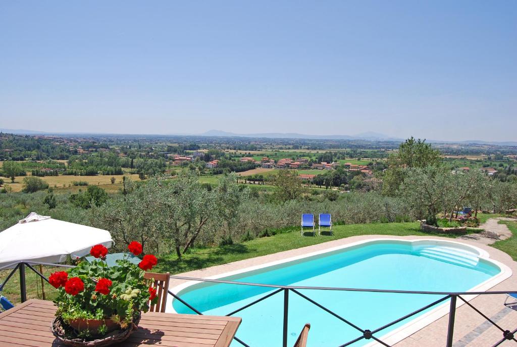 Villa con piscina y mesa con flores en Margherita Holiday Home, en Cortona