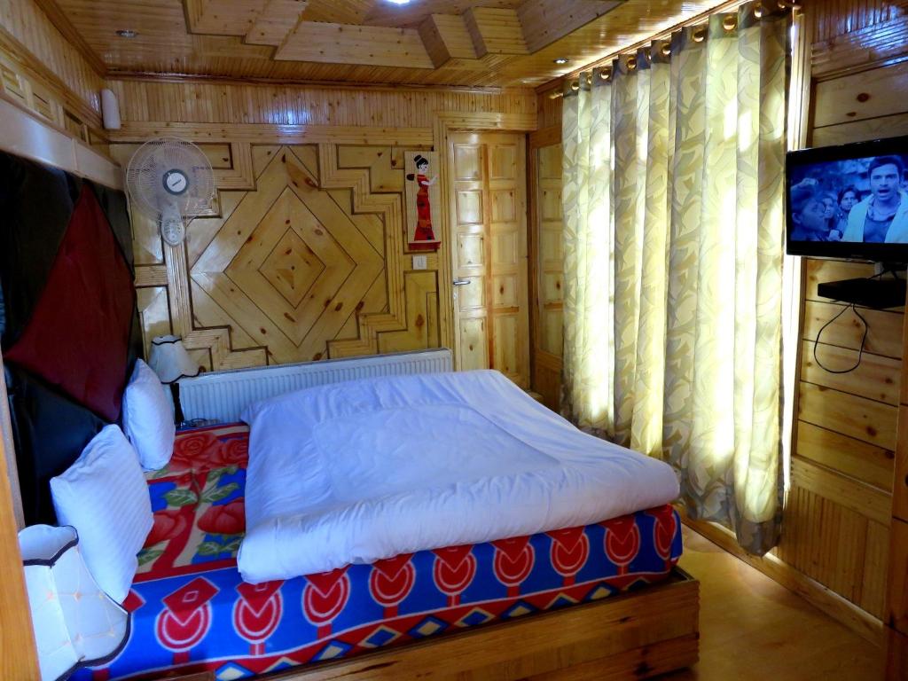 1 dormitorio con 1 cama y TV en una habitación en Hotel Nezer Holiday Inn, en Leh