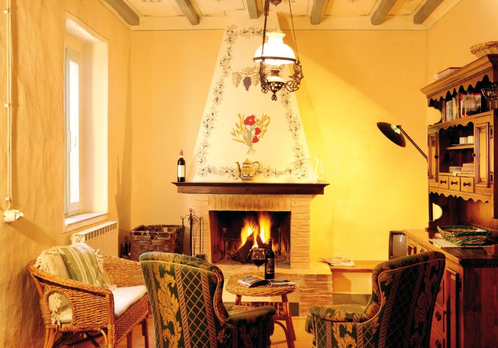 a living room with a fireplace and a table and chairs at Podere Soccorso in Montalcino