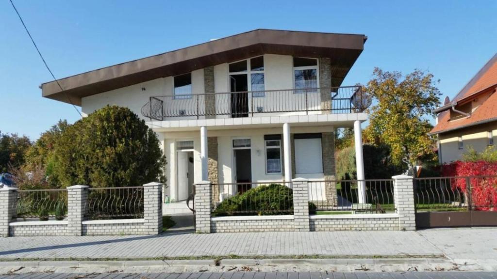 a large white house with a balcony at Fenyves Villa in Balatonfenyves