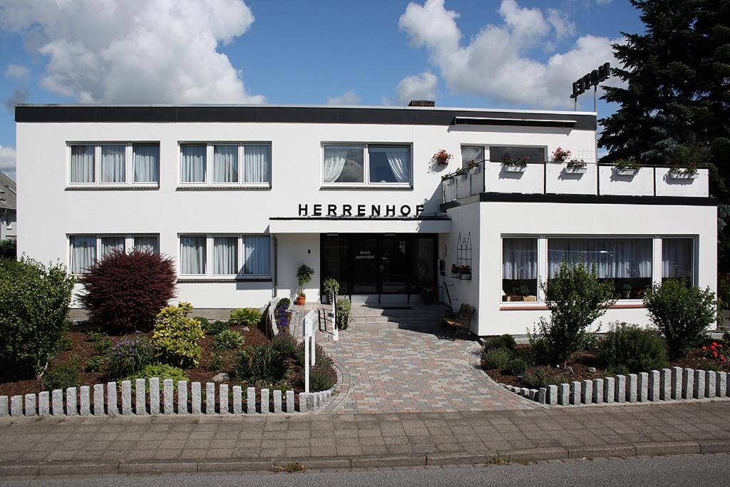 ein weißes Gebäude mit einem Schild auf der Vorderseite in der Unterkunft Hotel Herrenhof in Lübeck