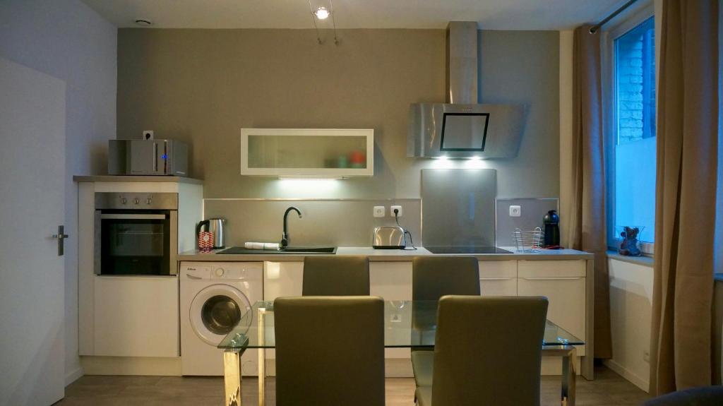 a kitchen with a table and a washing machine at Little Suite - Prisca in Lille