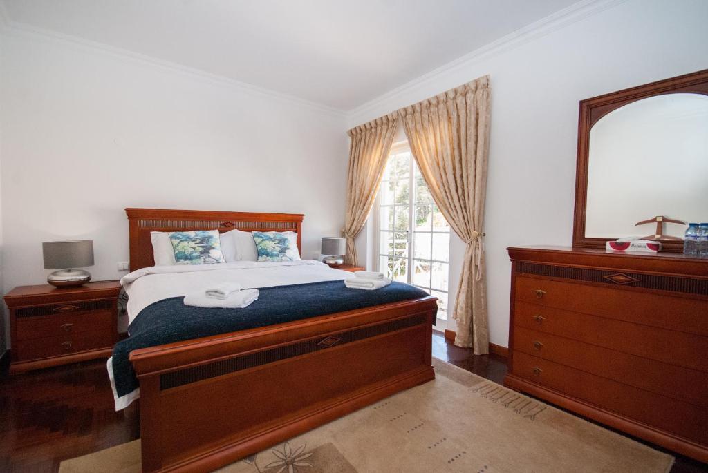a bedroom with a bed with a mirror and a dresser at Grace Villa in Aldeia de Juso