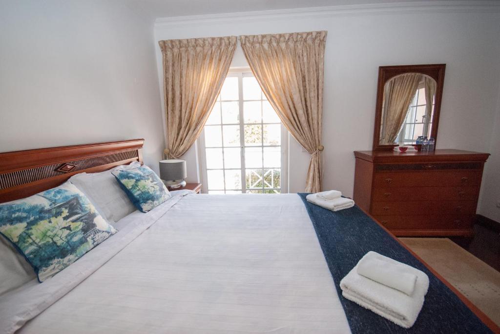 a bedroom with a large bed with two towels on it at Grace Villa in Aldeia de Juso