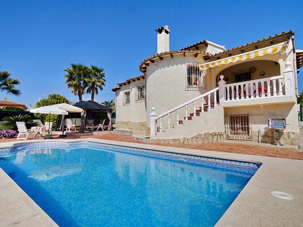 a large house with a swimming pool in front of it at Villa Salinas in Calpe