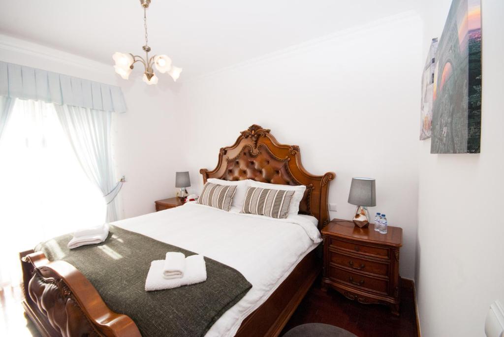 a bedroom with a bed with two white towels on it at Grace Villa in Aldeia de Juso