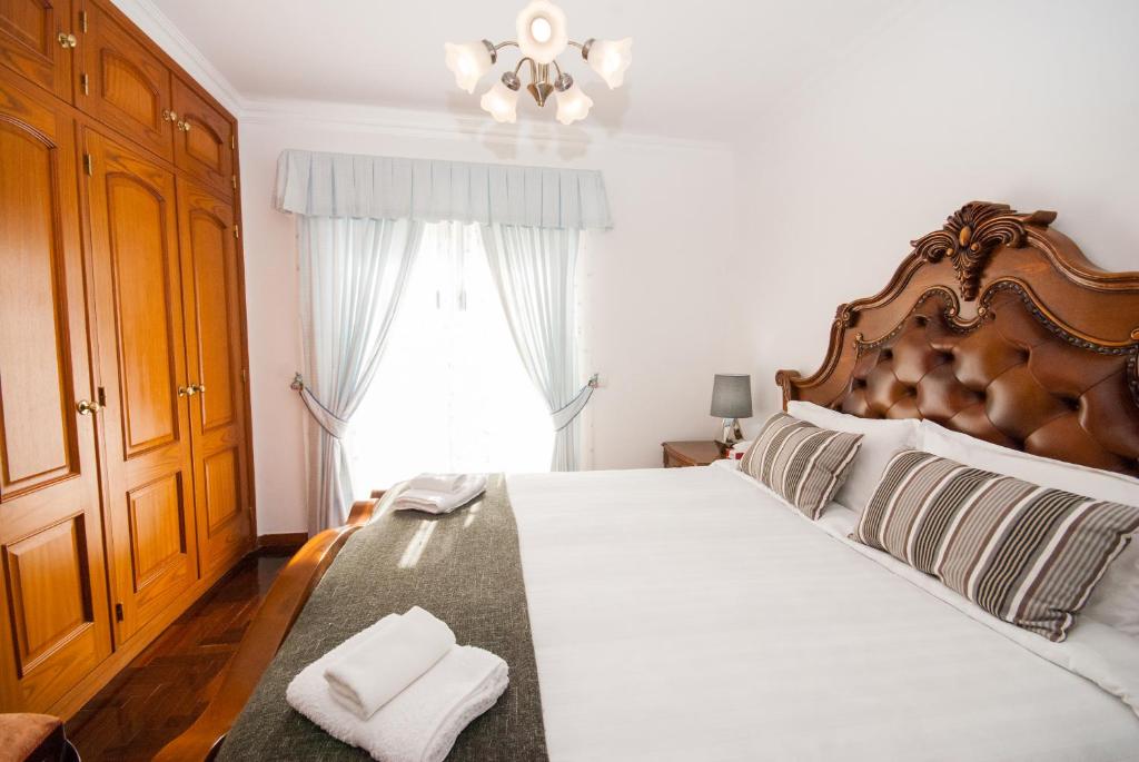 a bedroom with a large bed with two towels on it at Grace Villa in Aldeia de Juso
