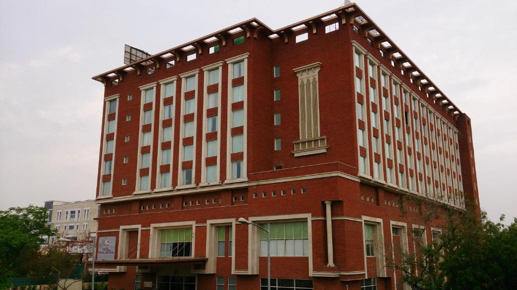 een groot gebouw van rode baksteen met een raam bij Hotel Royal Orchid Jaipur, Tonk Road in Jaipur