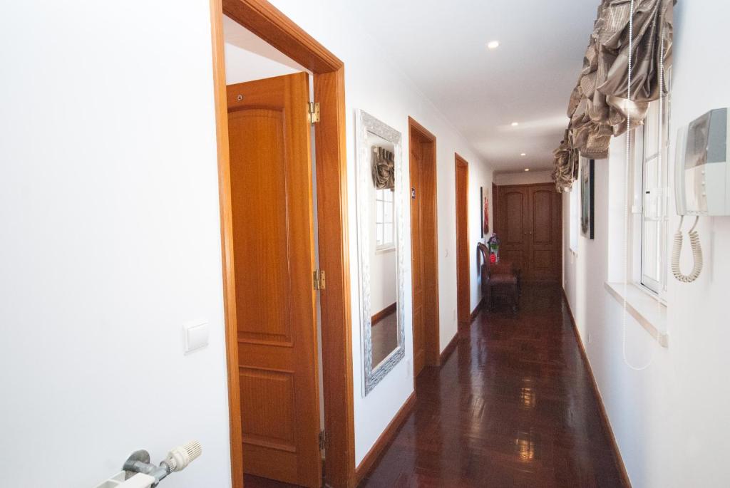 a hallway with wooden floors and a room with a door at Grace Villa in Aldeia de Juso