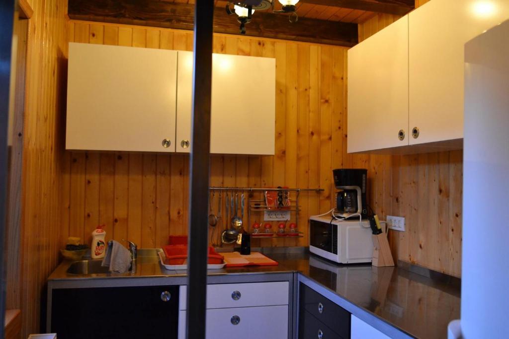 チェアラウにあるPensiunea Anaの木製の壁と白いキャビネット付きのキッチン