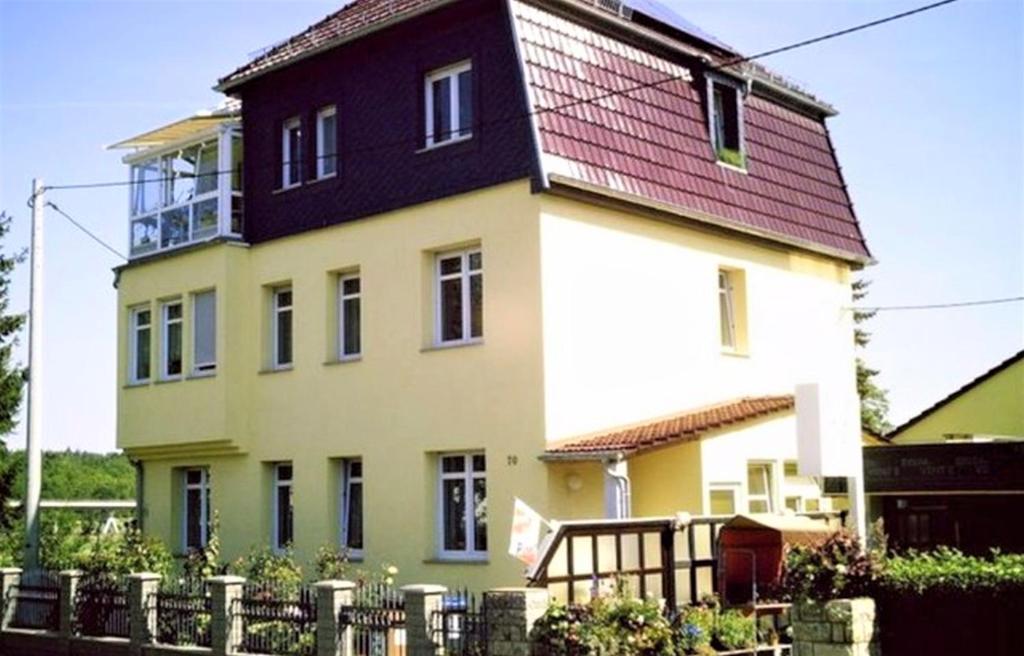 duży żółto-biały dom z czerwonym dachem w obiekcie Ferienwohnung Geratal w mieście Erfurt