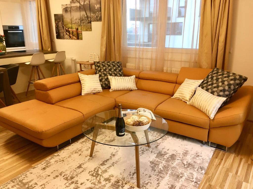 a living room with a brown couch and a glass table at Ferienwohnung am Hauptbahnhof in Vienna