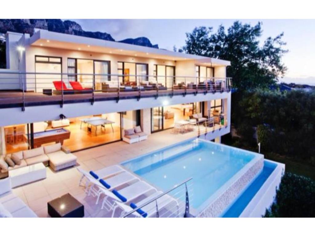 a large house with a swimming pool in front of it at Blue Emerald Villa in Cape Town