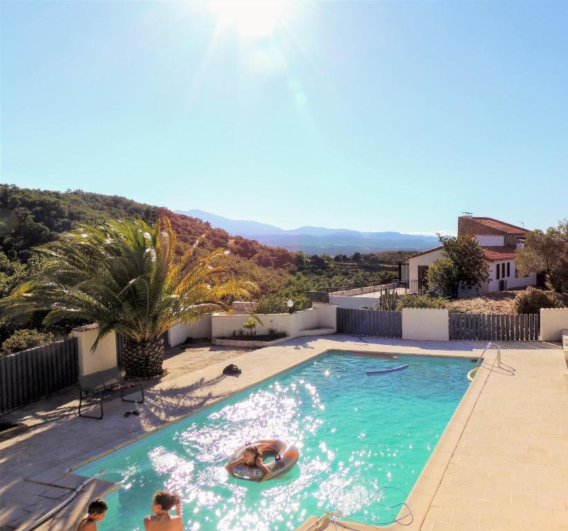 una piscina con dos personas en el agua en Mas Les Romarins, en Montesquieu