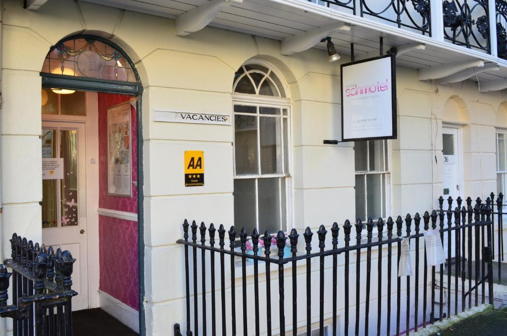 un edificio con una valla junto a una puerta roja en Motel Schmotel, en Brighton & Hove