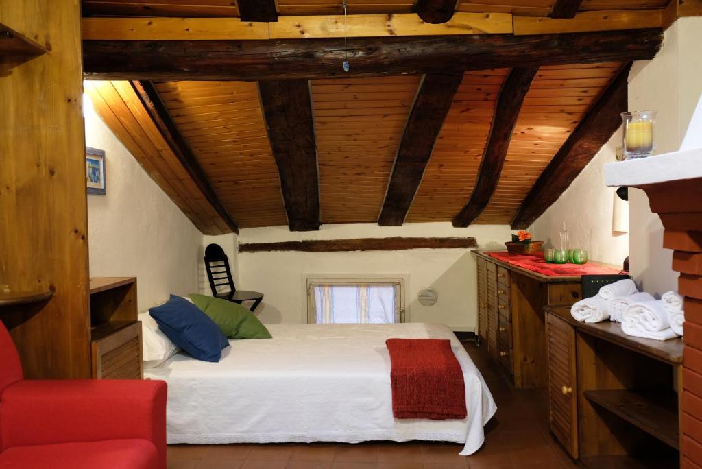 1 dormitorio con 1 cama en una habitación con techos de madera en Castiglione Lovely Mansarda en Bolonia