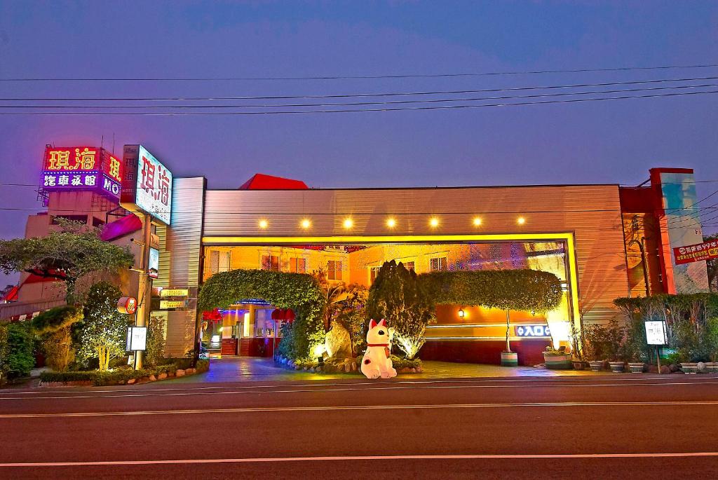 un edificio con un oso panda delante de una calle en Qi Hai Motel en Zhunan