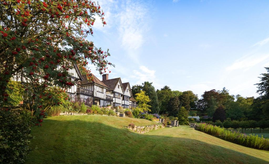 ein großes Haus auf einem Hügel mit einem grünen Hof in der Unterkunft Gidleigh Park- A Relais & Chateaux Hotel in Chagford