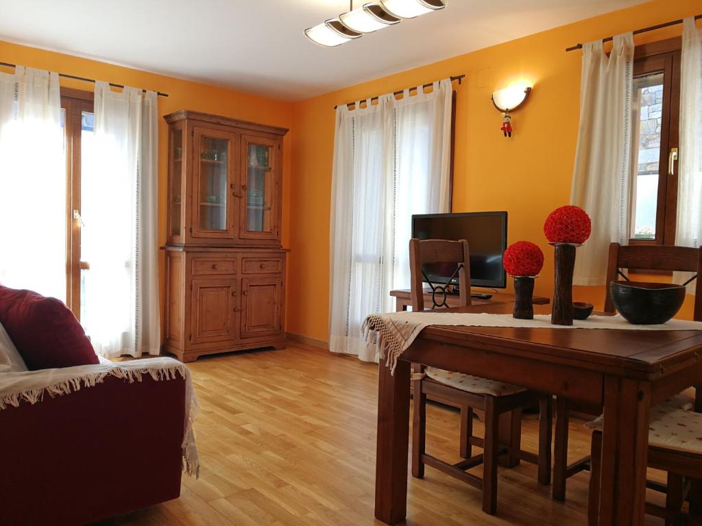 バルエラにあるTres Dormitorios Barruera Immovallの黄色の壁のリビングルーム(ダイニングテーブル付)