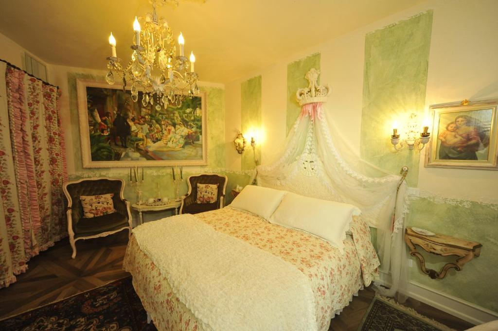 a bedroom with a bed and a chandelier at B&B La Maison degli Angeli in Desenzano del Garda