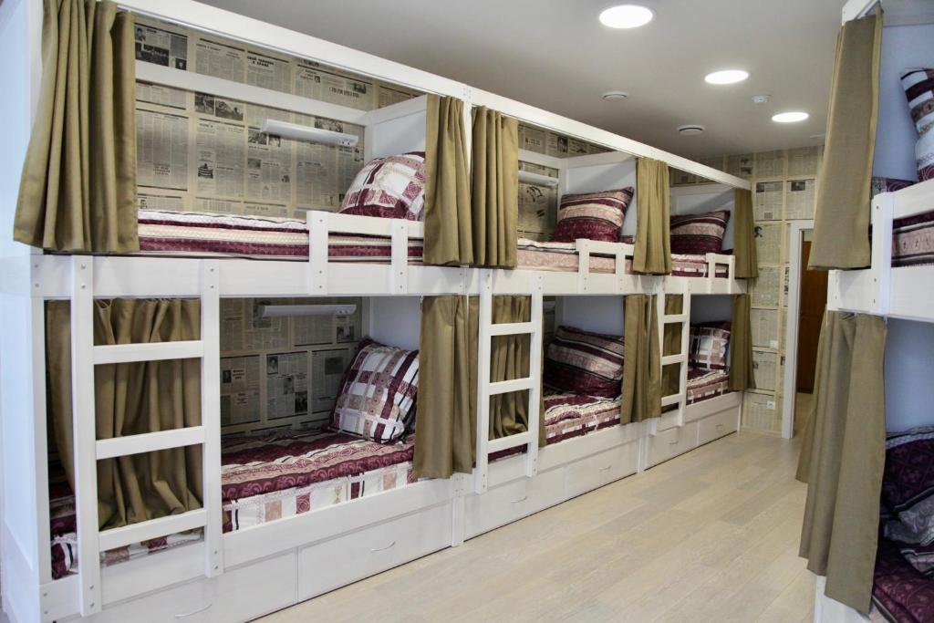 a room filled with bunk beds with curtains at Hostel1 Uralskih Rabochih in Yekaterinburg