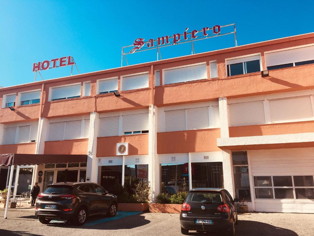 zwei Autos, die vor einem Hotel geparkt sind in der Unterkunft Hôtel Sampiero in Bastia