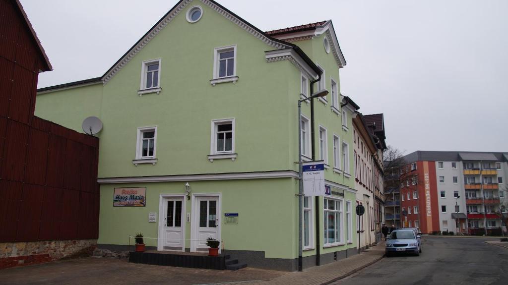 un edificio verde al lado de una calle en Pension Haus Maria en Mühlhausen