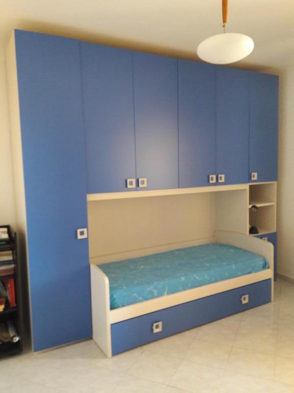 a room with blue cabinets and a bed in it at camera zona policlinico/università in Monserrato